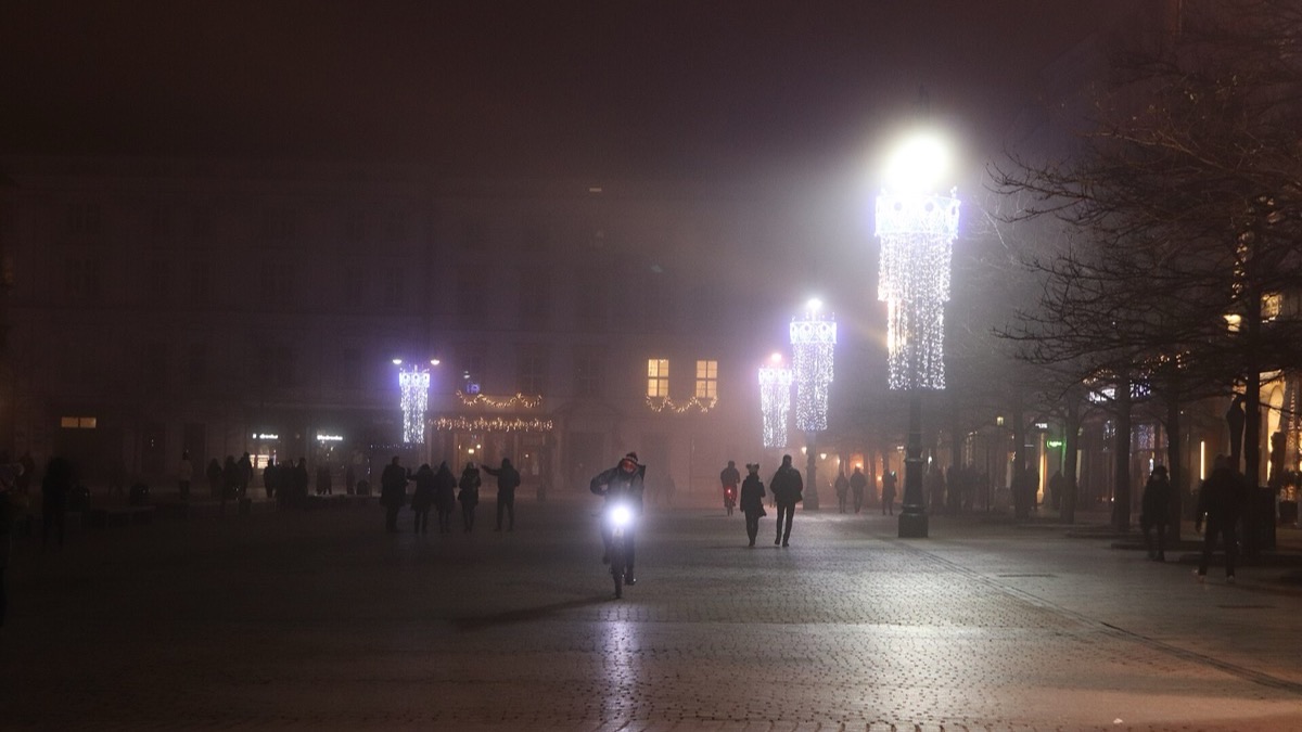 Kraków's Main Market Square lit up at night, with the Cloth Hall and St Mary's Basilica glowing.